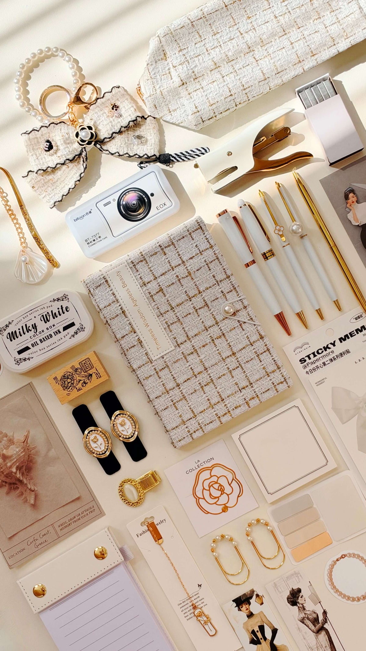 Cream-and-beige flat lay styled for the Ivory Velvet Edition, with a checked notebook, pens, sticky notes, camera, and coordinated accessories.